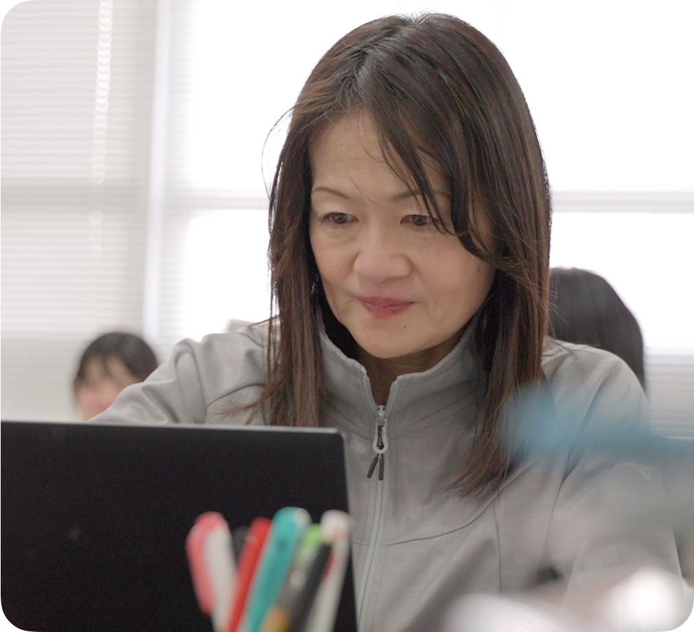 교실에 앉아 앞에 놓인 Chromebook 기기에 집중하고 있는 여성