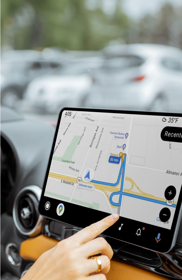 A finger pointing to a street map on a car navigation screen