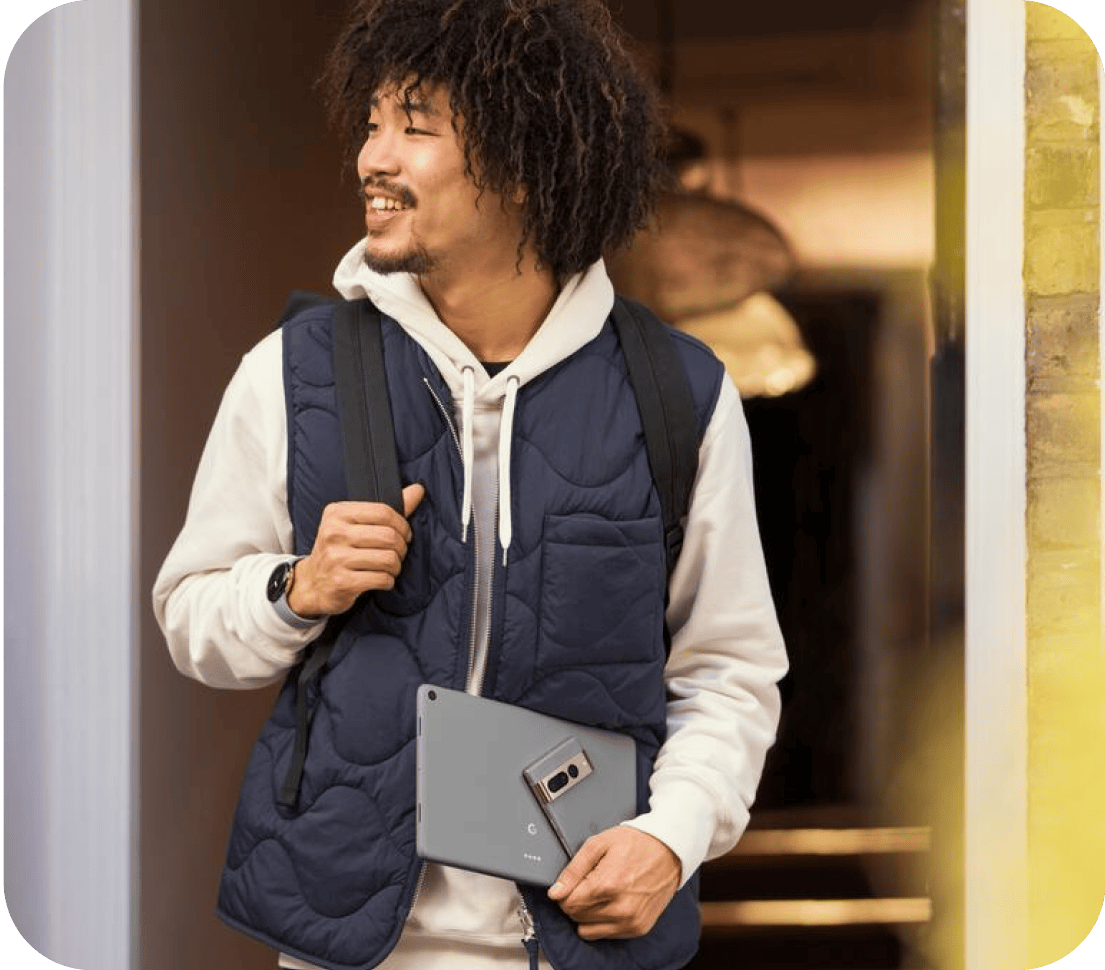 Man carrying a Google Pixel phone and a Google Pixel tablet