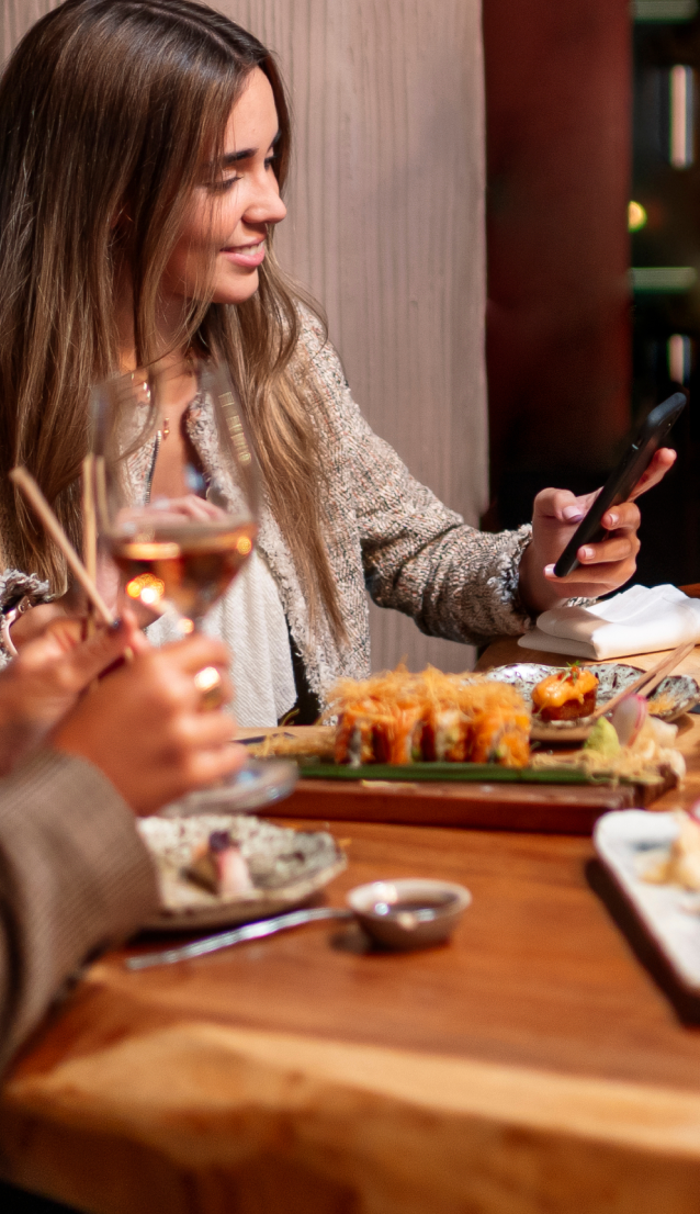 A woman using a messaging app to find restaurants near her hotel.
