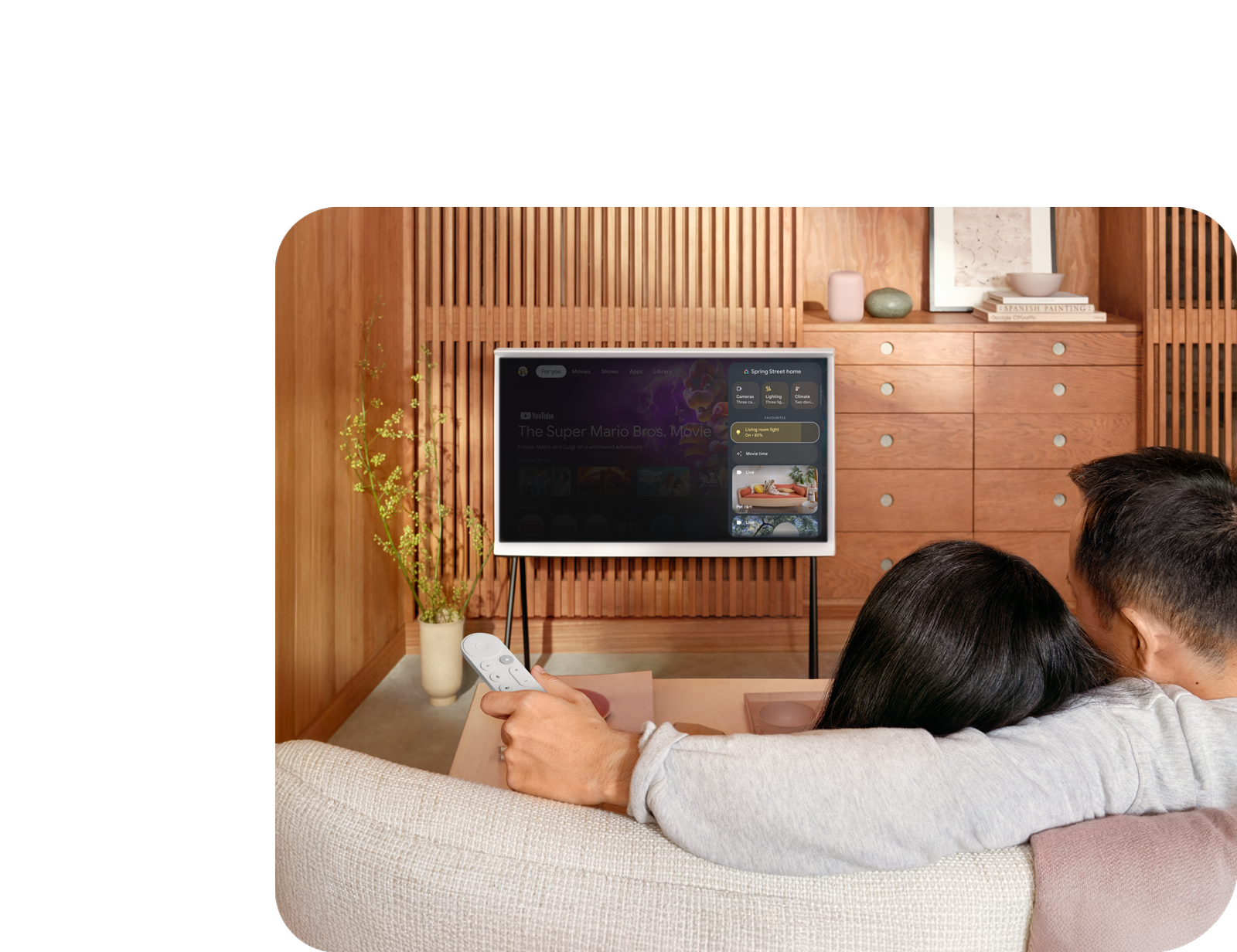 Image of a couple utilising their Google TV and Thread to change the lighting in their home.