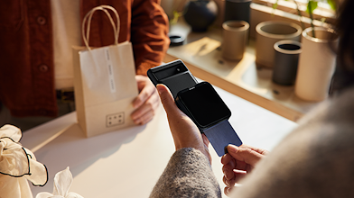 一位女店主使用連接 Pixel 行動裝置的可攜式信用卡機，處理顧客的購買交易。