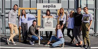 The team of Sepiia pose in front of their sign outside.