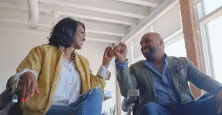 woman and man fist bump and smile at one another